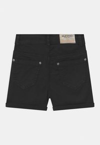 Pantaloni corti in denim nero con risvolti, dotati di due tasche posteriori con accessori decorativi e un'etichetta sulla vita.