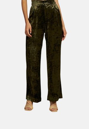 Pantalones de terciopelo de cintura alta y pierna ancha en verde oscuro. Presentan un suave brillo, pliegues verticales y una textura suave. Acentuados con un cinturón a juego.