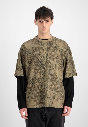 Olive green short-sleeve top featuring a textured snake skin pattern, with a round neckline and a black long-sleeve layer underneath.