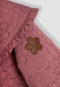 Padded švarkas dulkėtai rožinės spalvos, su gėlės formos siūlėmis ir raukšlėtu apykaklės kraštu. Įrengtos rudos odos etiketės su įspaustu užrašu "JoJo".