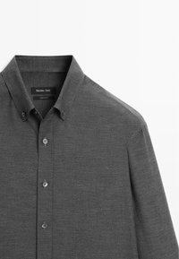 Grijze button-up shirt met een kraag, subtiele textuur en een voorpansluiting met grijze knopen, gelabeld "Massimo Dutti."
