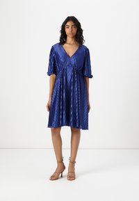 Blue pleated dress with a V-neckline and short, cuffed sleeves. Soft texture and flared silhouette, accentuated by a gathered waist.