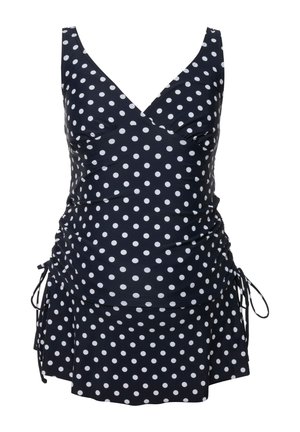 Costume da bagno navy a pois con lacci laterali regolabili, corpino arricciato e gonna svasata. Il tessuto ha una consistenza liscia e lucida.