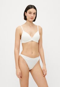Set di bikini bianco con reggiseno a scollo a V e spalline regolabili, abbinato a slip a vita bassa. Tessuto liscio, design minimalista, senza motivi visibili.