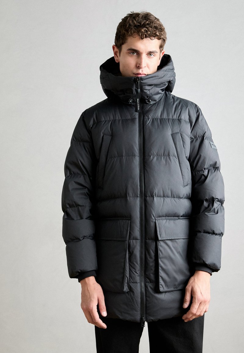 Schwarze Daunenjacke mit hohem Kragen, Reißverschluss und zwei Fronttaschen. Verfügt über ein gestepptes Design und eine glatte Textur.