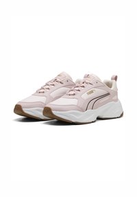 Różowe syntetyczne sneakersy o gładkiej fakturze, z białą podeszwą, czarnymi akcentami i złotym logo po boku. Wyposażone w sznurowadła oraz zapiętek z tyłu.