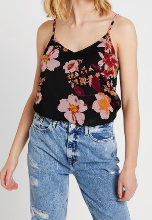 Camisole noire à fleurs avec des fleurs roses et orange, bretelles fines, décolleté en V et coupe ample, associée à un jean bleu clair déchiré.
