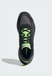 Čierna bežecká obuv s jednovrstvovým vrchom a zelenými akcentmi. Obsahuje čierne šnúrky, polstrovanú podrážku a polstrovaný golier pre pohodlie.