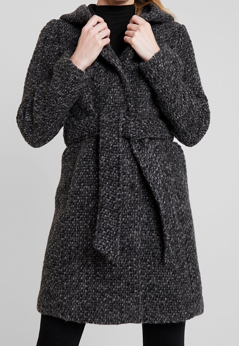 Manteau gris texturé avec capuche, ceinture à la taille et fermeture par boutons. Doté d'un tissu tricoté à motifs et de manches longues, arrivant jusqu'à mi-cuisse.