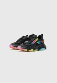 Black sneakers with mesh and rubber accents, featuring a wavy sole in gradient colors, including pink, yellow, and green. Lightweight design.
