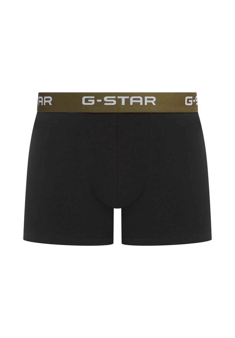 Boxer-briefs noirs avec une ceinture G-Star dorée et une lettre blanche. Le matériau semble lisse avec un design ajusté et sans motifs supplémentaires.