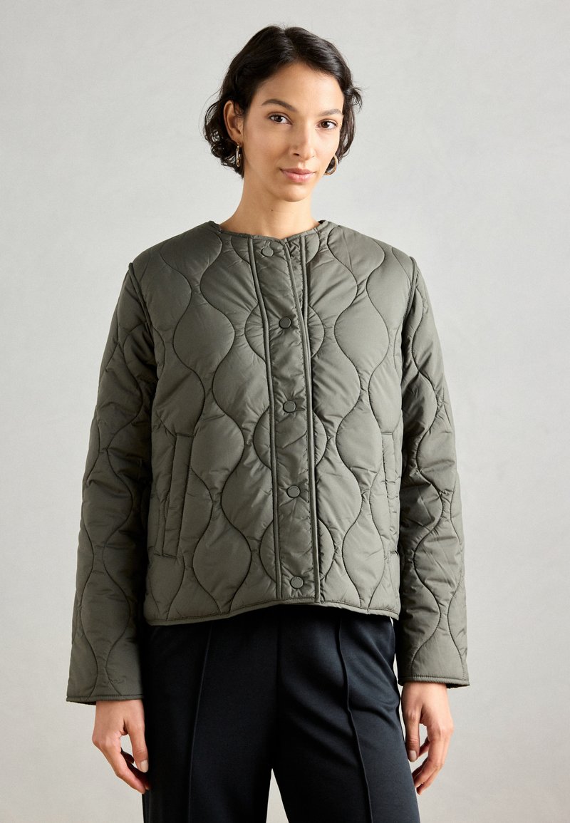 Olīvu zaļš quilted jaka ar apaļu dekoltē, ar tonālu šuvi un priekšējiem pogām. Izstrādāta ar plūstošu piegulšanu un strukturētu rakstu.
