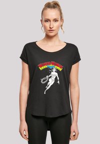 Svart T-skjorte med rund hals og oppbrettede ermer, med et grafisk bilde av Wonder Woman i hvitt, omkranset av fargerik tekst og stjerner.