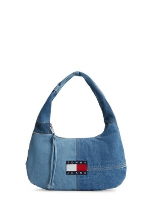 Sac d'épaule en denim bleu bicolore avec une écusson logo Tommy Jeans et un tirette de fermeture éclair sur un fond blanc uni.