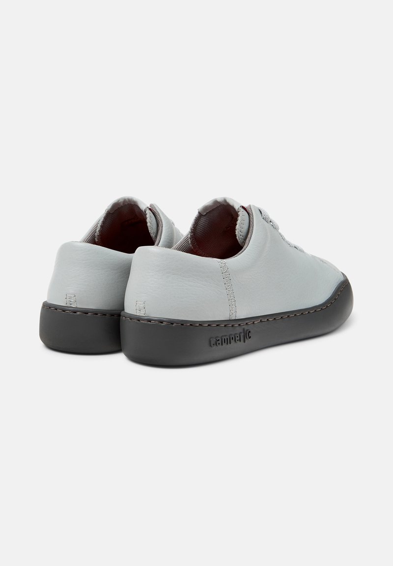 Hellgraue Ledersneaker mit runder Form, schwarzem Gummialausschnitt und kontrastierenden Nähten. Besitzt ein glattes Obermaterial und eine weiche Innenauskleidung.