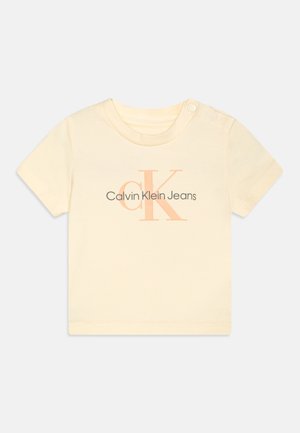 Kurzärmeliges, cremefarbenes Baumwoll-T-Shirt mit Druckknopf an der Schulter und "Calvin Klein Jeans"-Logo in Grau- und Pfirsichfarben.