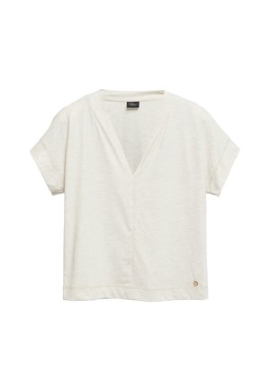 Damska bluzka z krótkim rękawem w jasnobeżowym kolorze, z dekoltem w serek, o luźnym kroju i małym okrągłym metalowym logo blisko dołu na jednolitym tle.