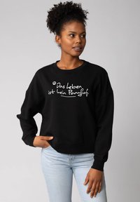 Zwarte sweatshirt met een losse pasvorm, voorzien van witte tekst "Das leben ist kein Ponyhof" op de voorkant. Gemaakt van zachte, gestructureerde stof.