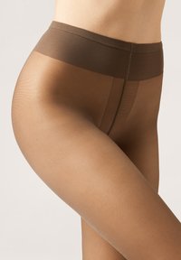 Brune, transparente strømpebukser med mat finish, der har en bred, blød talje og sømløst design, som glat former benet.