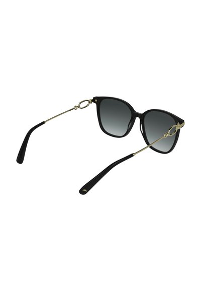 Lunettes de soleil noires avec une monture brillante, verres gris dégradés, accents métalliques dorés et branches noires courbées. Présentent un design unique de charnière.