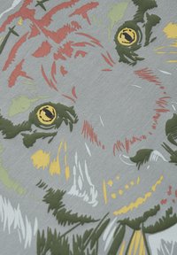 Puuvillakangas, jossa on leijonan kasvokuvio oliivinvihreänä, oranssina, keltaisena ja valkoisena vaaleanharmaata taustaa vasten, yksityiskohtaisine silmineen.