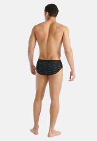 Czarne kąpielówki z geometrycznym wzorem w ciemnoszarym kolorze. Wygodna gumka w pasie, niski stan, podkreślające dopasowany krój i gładką teksturę.