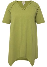 Oliven grøn T-shirt med korte ærmer, V-hals og flettede detaljer langs skuldrene. Fremstillet af blødt, letvægtsmateriale med en asymmetrisk kant.