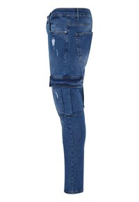 Jeans bleu foncé avec une coupe ajustée, présentant des détails usés et des poches de style cargo sur la cuisse, fabriqués en tissu en denim.