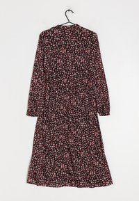 Robe noire à fleurs avec des manches longues, présentant un corsage ajusté et une jupe fluide ornée de motifs de fleurs roses et blanches.