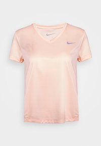 Vaaleanpunainen Nike lyhythihainen V-päänteinen urheilupaita, jossa on verkkomateriaalia ja pieniä harmaita Nike-swoosh-logoja rinnassa ja kauluksen sisäpuolella.