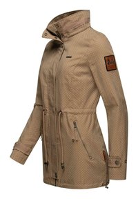 Veste imperméable beige avec un motif à pois, col montant, cordon de serrage ajustable, poches zippées sur les côtés et patch logo sur la manche.