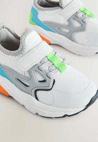 Weiße Sportschuhe mit grauen, türkisfarbenen und neongrünen Akzenten. Verfügt über ein Obermaterial aus Mesh, einen Klettverschluss und eine strukturierte Gummisohle.