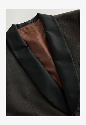 Brūns rakstains bleizers ar melnu satīna šallējo apakšmalu un brūnu oderi. Tam ir smalks ģeometrisks raksts uz auduma.