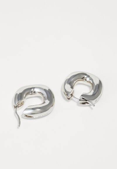 Pair of shiny silver hoop earrings with thick rounded design and open clasps on a white background.