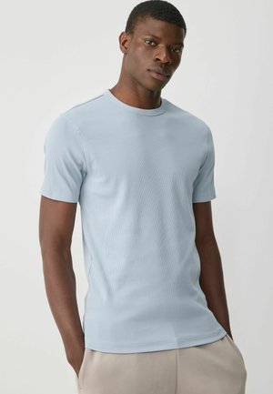 Camiseta de manga corta de color azul claro hecha de tejido acanalado, con un cuello redondo y un diseño ajustado. Textura suave con costuras mínimas.