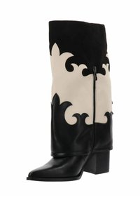 Bota de cuero en blanco y negro a media pantorrilla con patrones decorativos en forma de llama, cremallera lateral, punta afilada y tacón cuadrado.