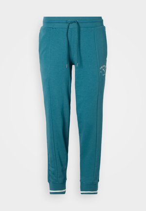 Turkise joggebukser med snøring i livet, lommer foran, innsnevrede ben, ermet ved anklene med hvit stripe og liten hvit logo på øvre lår.