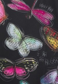 Svart tyg med färgglada fjärilsillustrationer i rosa, grön och gul med intrikata detaljer och texten "JAG ÄR MIN PASSION."