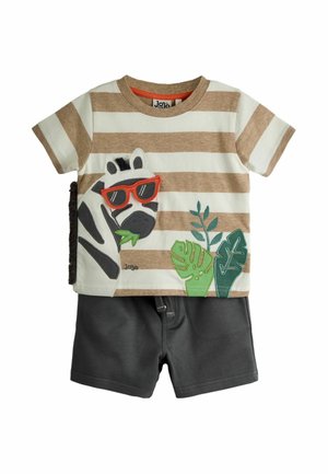Dieťaťa oblečenie s béžovo-bielym pruhovaným tričkom, na ktorom je zebra s červenými slnečnými okuliarmi a zelenými listami, v kombinácii s tmavosivými kraťasmi.