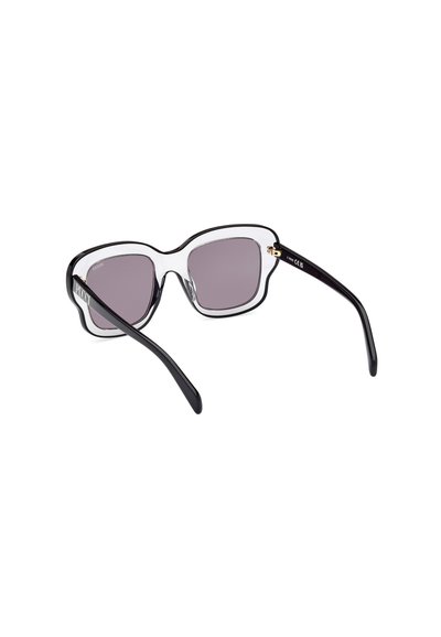 Gafas de sol sobredimensionadas en negro y transparente con lentes moradas degradadas y un marco grueso y ondulado. Presenta detalles en oro en las patillas.