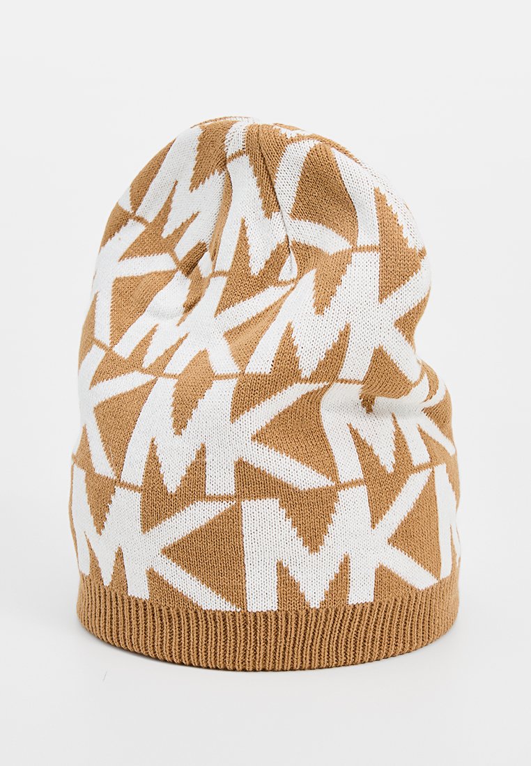 Czapka dzianinowa z brązowym i białym geometrycznym wzorem, z powtarzającymi się kształtami 'M'; miękka tekstura, zaokrąglony szczyt i prążkowany dolny brzeg.