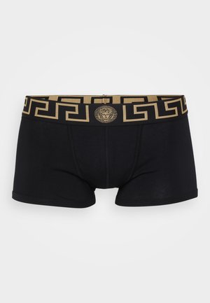 Black boxer briefs featuring a gold geometric-patterned waistband and a medallion logo at the center. Soft cotton material with a snug fit.