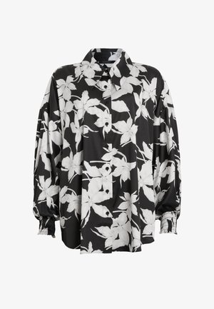 Cămașă florală alb-negru cu guler larg, mâneci strânse și textură de material neted. Are modele mari de flori.