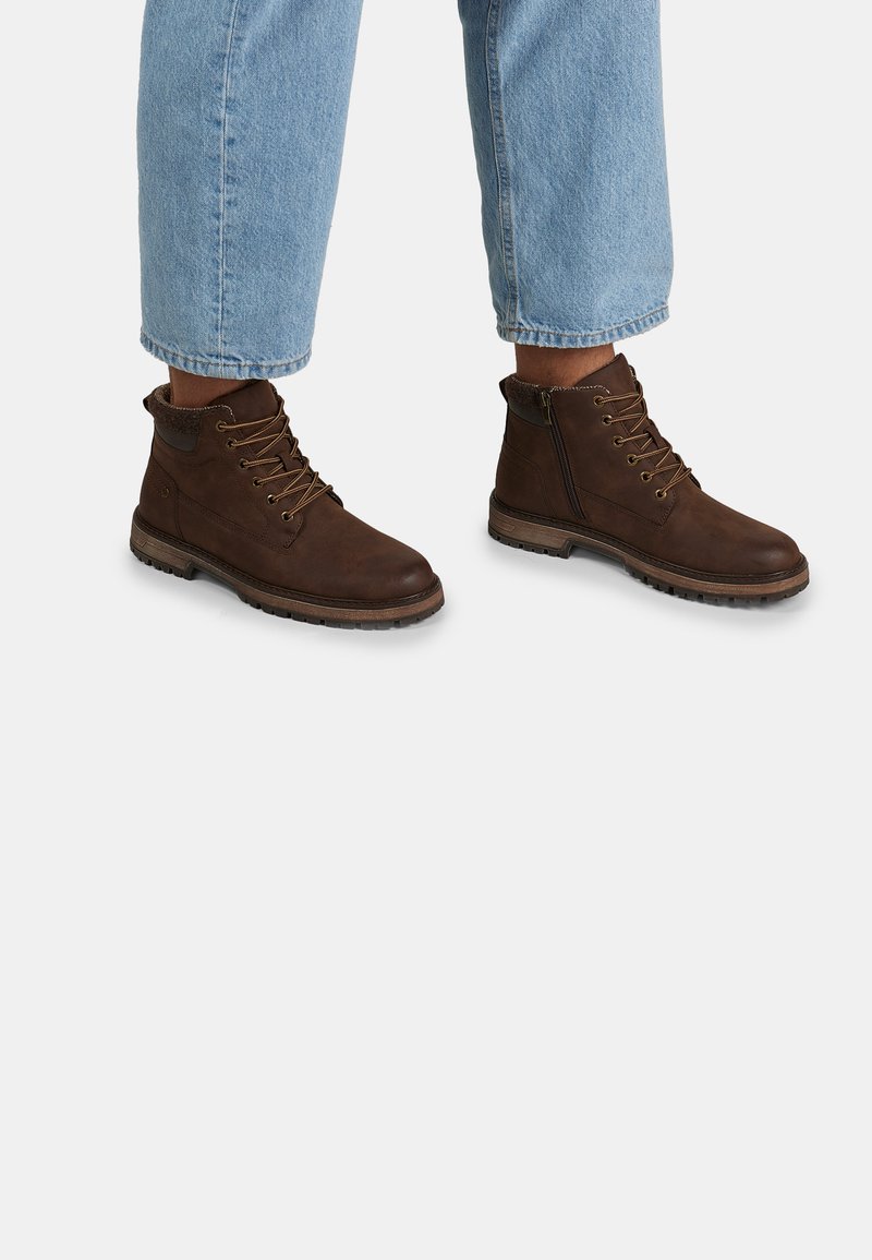 Stivali in pelle marrone con design allacciato, occhielli in metallo e zip laterale. Suola testurizzata e colletto imbottito per il comfort.