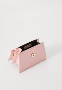 Pink leather wallet with a structured design, featuring a gold snap closure, black interior, and two side flaps for added style.