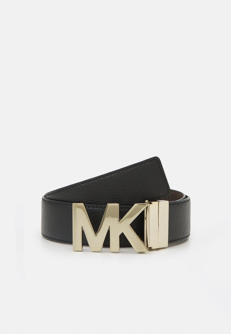 Ceinture en cuir noir roulée avec une grande boucle métallique dorée portant le logo MK sur un fond gris clair uni.
