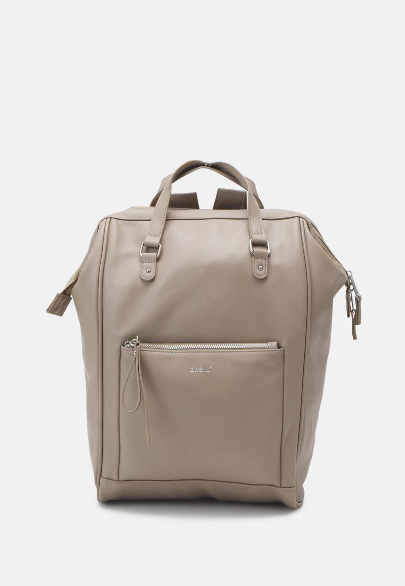 Sac à dos rectangulaire beige avec poignées supérieures, poche avant zippée, bretelles réglables et curseurs de fermeture éclair argentés.