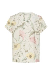 Blouse crème à manches courtes avec un délicat imprimé floral en jaune pastel, rose et vert sur un tissu doux.