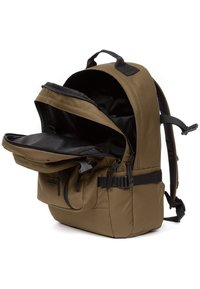 Sac à dos en tissu marron avec un intérieur noir. Comprend une poche zippée à l'avant, des bretelles réglables et une poignée supérieure pour un transport facile.