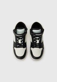 Mustvalge kõrge raamiga sneakers, millel on sile naha ülemine osa, perforatsiooniga varbavöö, mustad nööbid ja logo aktsendid külgedel.